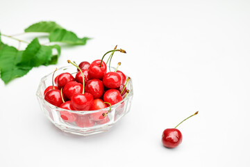 Fresh healthy ripe cherries in glass bowl on white background. Summer sweet seasonal organic fruits. Selective focus.