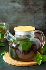 Therapeutic herbal tea. Hot mint tea on a dark  stone or concrete background. Copy space.