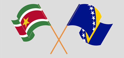 Crossed and waving flags of Suriname and Bosnia and Herzegovina