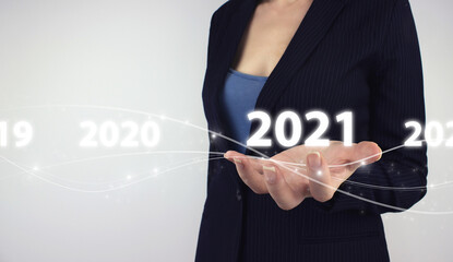 Business new year card oncept. Hand hold digital hologram Year two thousand and twenty one on grey...