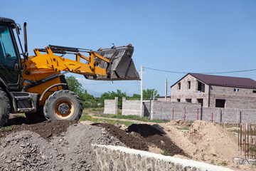 Fototapeta na wymiar excavator and new building in the field. build a house