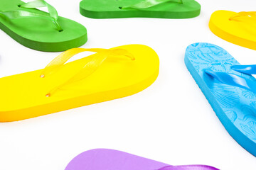 several multi colored rubber flip flops on a white background