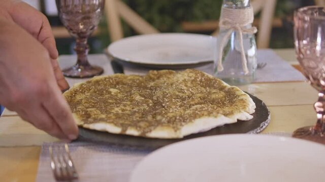 Baking Manakish. Lebanese Food:   A cook preparing zaatar pizza 