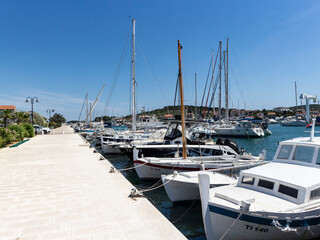 Fototapeta premium Jezera, Croatia-June 3rd, 2021: Anchored fishing boats in the port of small fishing village Jezera, located on Murter island, Croatia at the start of summer season