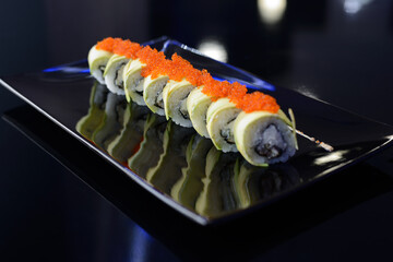 Sushi rolls on black dish. Japanese food.