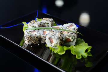 Sushi rolls on black dish. Japanese food.