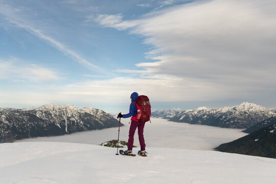 Person Snowshoeing In The Mountains Above The Clouds 