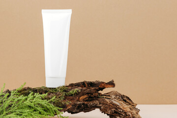 Natural natural cosmetics. A tube of cream or lotion sits on a piece of wood. Facial and body care products. Copy space