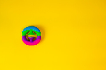 Viral trendy colorful anti-stress sensory toy. Silicone fidget push gadget. Snapperz antistress expander for fine motoric skills. Flat lay on yellow background. Picture with place for text.