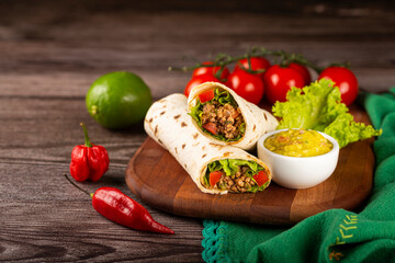 Mexican burritos stuffed with beef and salad.