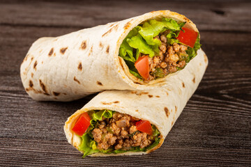 Mexican burritos stuffed with beef and salad.