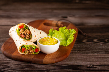 Mexican burritos stuffed with beef and salad.