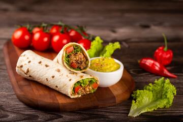 Mexican burritos stuffed with beef and salad.