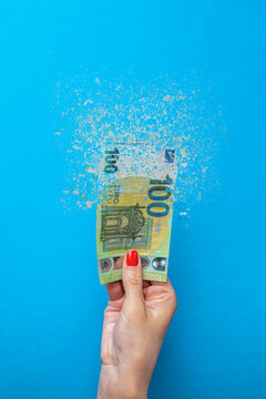 Euro inflation. Inflation in Europe, hyperinflation. Banner with blue background. One hundred euro banknote sprayed in the hand of a man on a blue background.