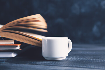 an open book and a cup on the table