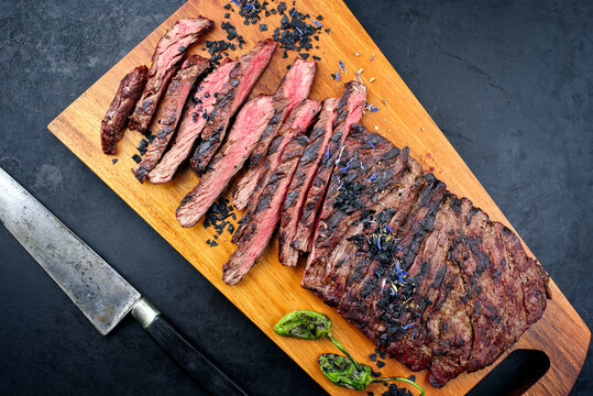 Modern style traditional barbecue wagyu bavette steak with green chili and spices served as top view on a wooden design board
