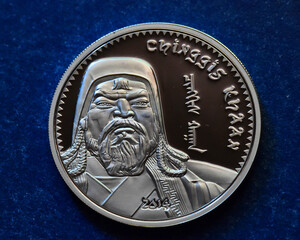 una moneda de plata de mongolia con el retrato de genghis khan
