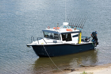Fototapeta na wymiar Repair of a fishing boat motor near the shore