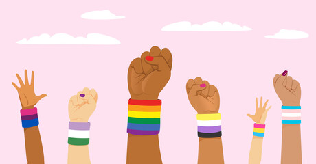 Group of raised up fists wearing different LGBT identity flags on wristband