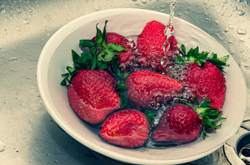 Fresh strawberries in a bowl on a background
