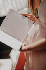 Pregnant woman read with white book mockup in hand on shine background