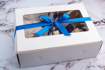 food gift box with blue bow on marble countertop - obrazy, fototapety, plakaty