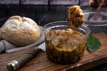 chicken and pickled aubergines in pots with very elegant knife and fork and homemade country bread...