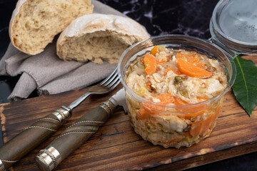 chicken and pickled aubergines in pots with very elegant knife and fork and homemade country bread on wooden board