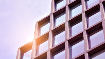 Abstract image of looking up at modern glass and concrete building. Architectural exterior detail of office building. Industrial art and detail. Sunrise.