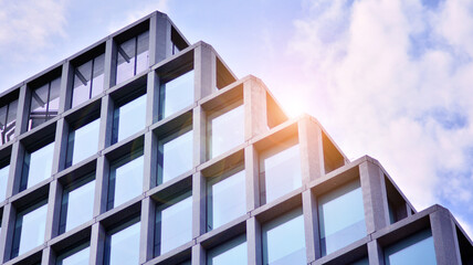 Abstract image of looking up at modern glass and concrete building. Architectural exterior detail of office building. Industrial art and detail. Sunrise.