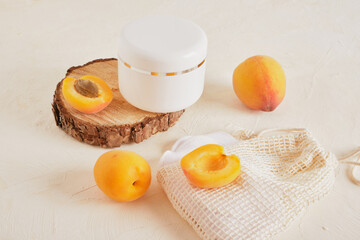 apricots plastic white jar for cream or cosmetics on a wooden podium from a saw cut wood on a light background