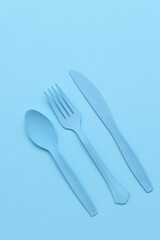 flat lay blue plastic utensils on a blue background
