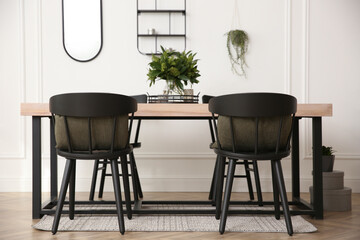 Stylish wooden dining table and chairs in room. Interior design