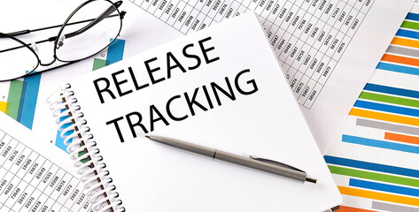 Notebook with text RELEASE TRACKING . Diagram and white background,Business
