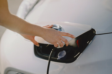 Woman charging electro car at the electric gas station