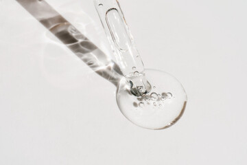 A drop of cosmetic oil falls from the pipette - obrazy, fototapety, plakaty