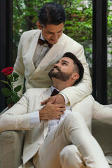 LGBTQ gay couple sitting together in living room in wedding ceremony