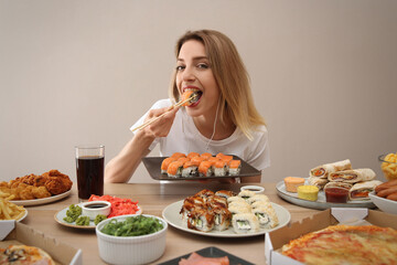 Food blogger eating at table against beige background. Mukbang vlog
