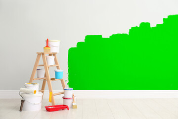Decorator's kit of tools and paints near light wall indoors