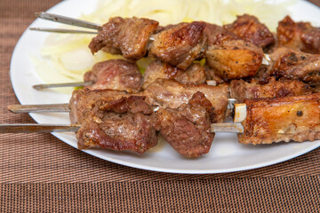 fried kebabs pieces of meat on metal skewers
