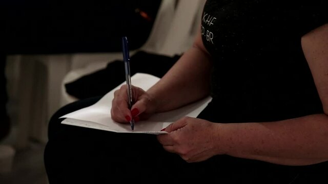 Mulher com unhas vermelhas escreve