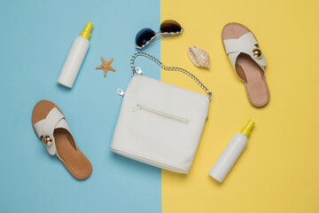 Women's bag, shoes, creams and accessories on a yellow and blue background. Flat lay.