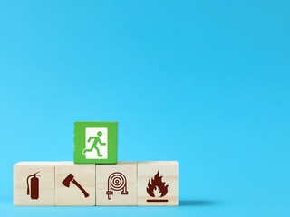 Wooden blocks with fire safety exit icons isolated on blue background. Fire safety protection...