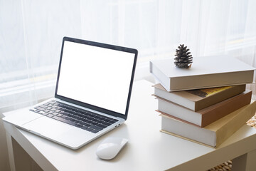 Laptop or computer notebook with blank white screen on white table with mouse. Home interior or office background.