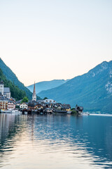 Scenic view of famous Hallstatt lakeside town reflecting in Hallstattersee lake in the Austrian Alps on a sunny day in summer, Salzkammergut region, Austria