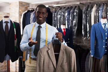 Male customer demonstrating his choice of suit in shop. High quality photo
