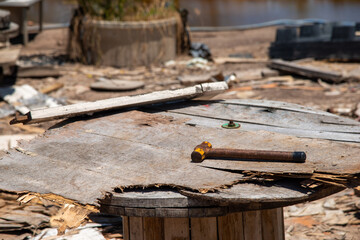 wood and rust head iron hammer lying on wooden board with outdoor workshop
