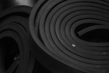 Close-up rubber sealing strips for waterproof doors. A pile of rubber twisted into rolls.