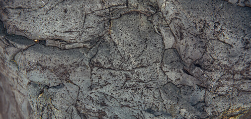 Abstract stone background. Rough surface of gray rock with cracks and natural pattern, close up. Texture for design.