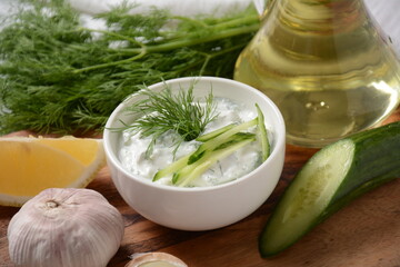 Traditional greek dip sauce or dressing tzatziki prepared with grated cucumber sour cream yogurt olive oil and fresh dill.